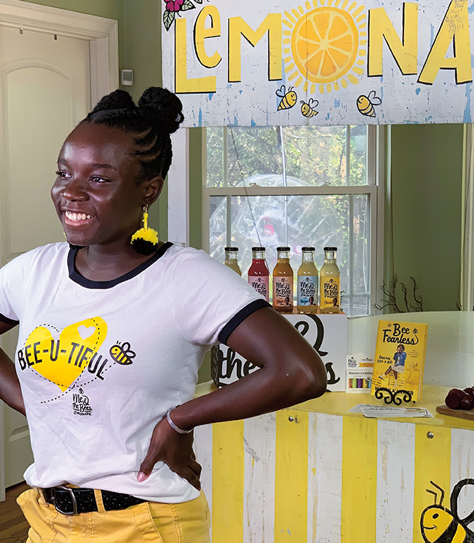 Teen standing in front of a her lemonade stand