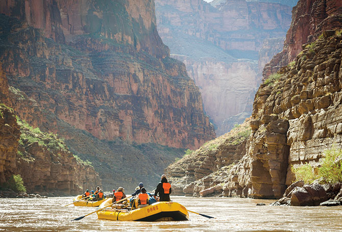 Rafters float down the Colorado River at the bottom of the Grand Canyon.