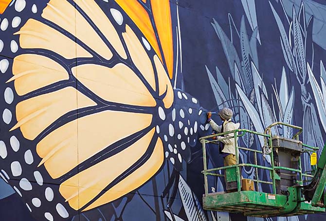 Artist painting a giant monarch butterfly