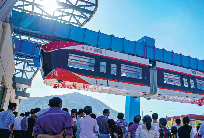 Enlargeable photo of people looking up towards an elevated train