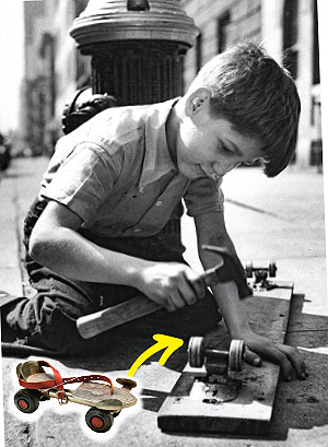 Black & white photo of a boy making a homemade skateboard with nails and a hammer